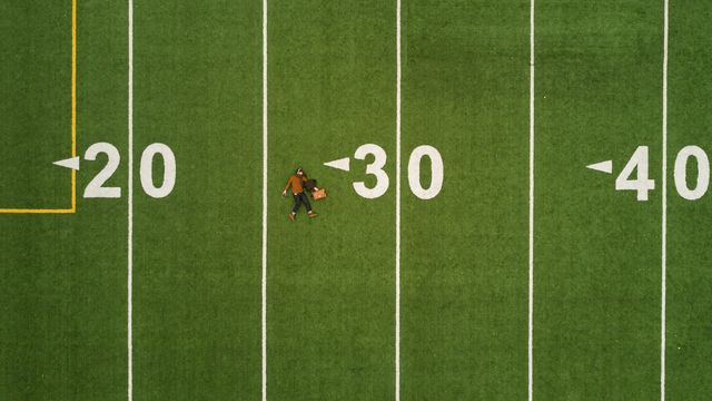 man lying on 30 yards on football field