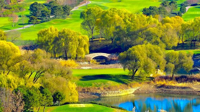 Autumn golf course with colorful trees and a bridge