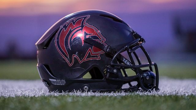 red and black football helmet on green grass